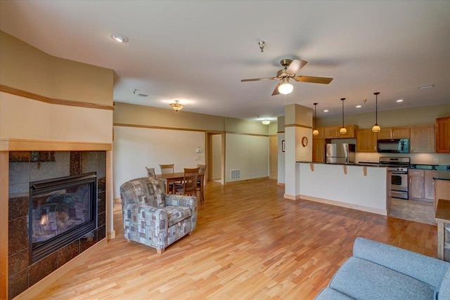 6767 Frank Lloyd Wright Ave Unit 219, Middleton, WI 53562 - living area with light wood-type flooring, ceiling fan, a fireplace, baseboards, and recessed lighting