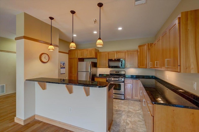 6767 Frank Lloyd Wright Ave Unit 219, Middleton, WI 53562 - kitchen featuring appliances with stainless steel finishes, a peninsula, a breakfast bar, dark stone countertops, and hanging light fixtures