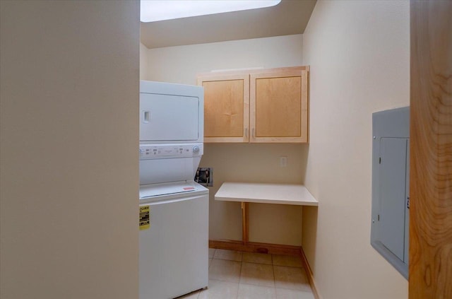 6767 Frank Lloyd Wright Ave Unit 219, Middleton, WI 53562 - laundry area featuring stacked washing machine and dryer, cabinet space, baseboards, light tile patterned flooring, and electric panel