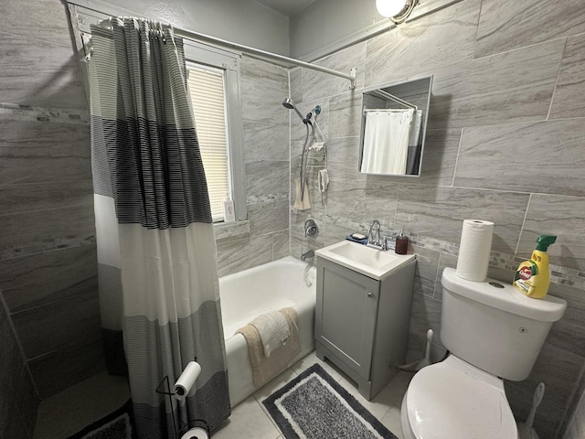 full bath featuring toilet, shower / tub combo, vanity, and tile walls