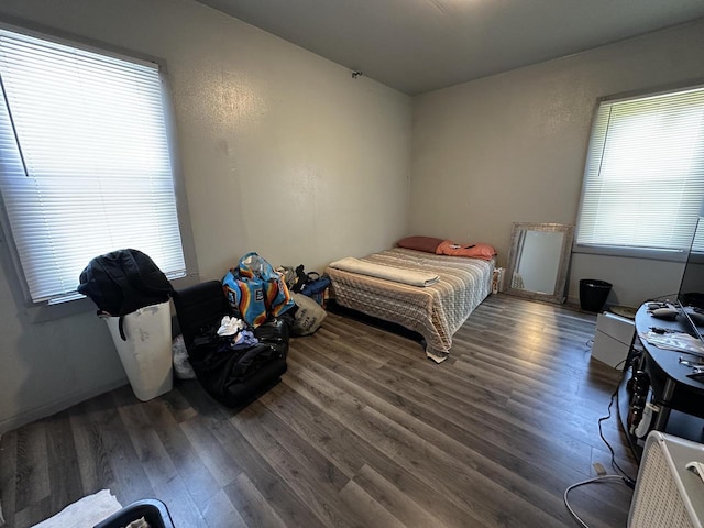 bedroom featuring wood finished floors and multiple windows