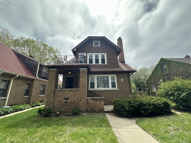 5733 W Philip Pl, Milwaukee, WI 53216 - view of front of property featuring a balcony, a chimney, a front yard, and brick siding