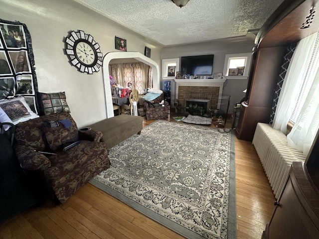 5733 W Philip Pl, Milwaukee, WI 53216 - living area with a textured ceiling, a fireplace, hardwood / wood-style flooring, and arched walkways