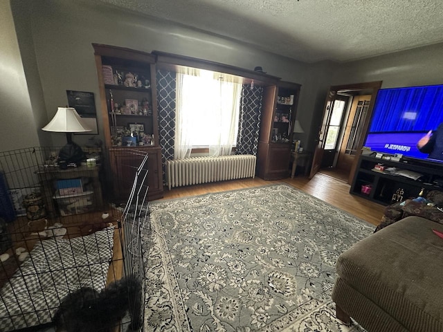 5733 W Philip Pl, Milwaukee, WI 53216 - living room featuring radiator, wood finished floors, and a textured ceiling