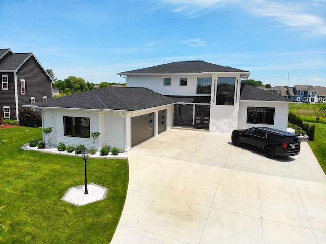 view of front of house with an attached garage, a front lawn, roof with shingles, driveway, and a residential view