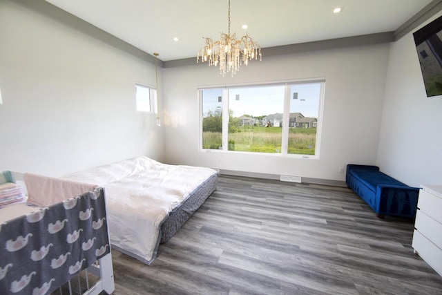 bedroom with wood finished floors, recessed lighting, and a chandelier