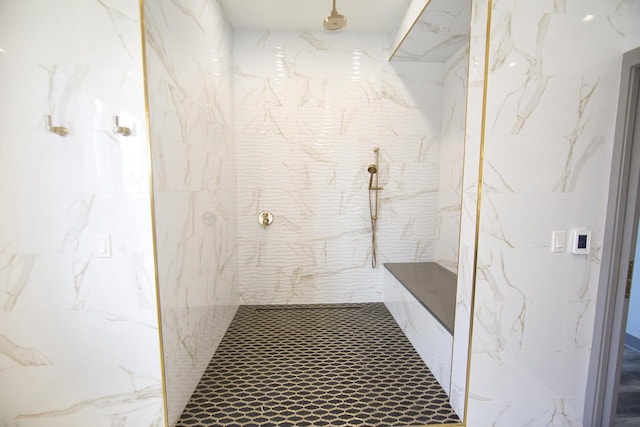 bathroom featuring a marble finish shower