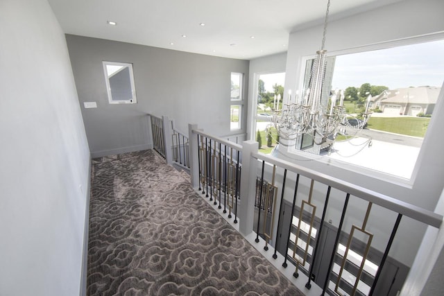 corridor with a chandelier, an upstairs landing, recessed lighting, and baseboards