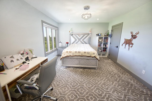 carpeted bedroom with a desk and baseboards