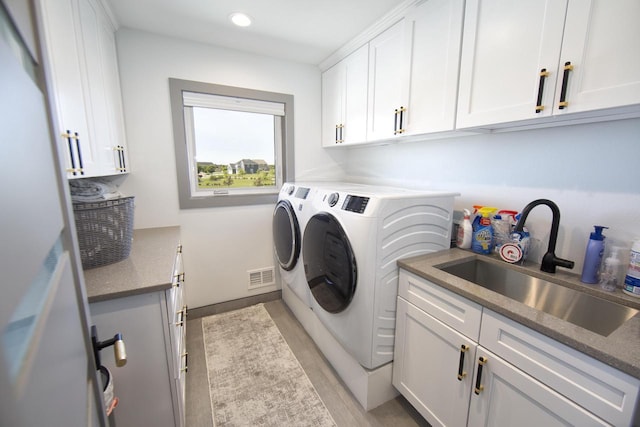 laundry room with cabinet space, washing machine and dryer, light wood-style flooring, and recessed lighting