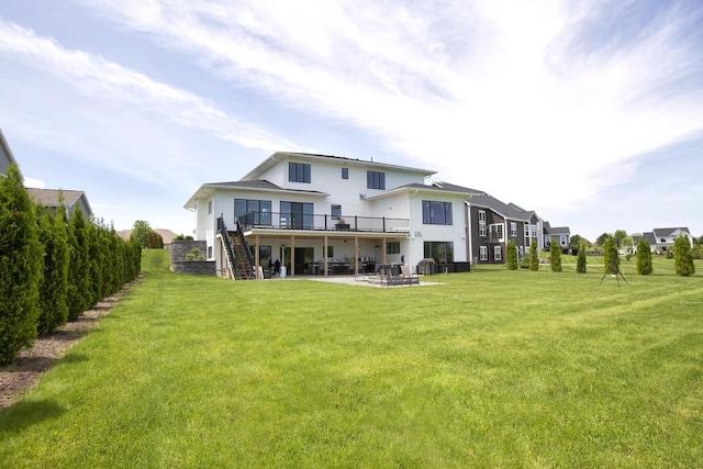 rear view of house with stairway, a patio area, a lawn, and a deck