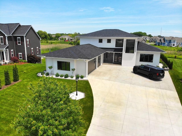 view of front facade featuring an attached garage, a residential view, a front yard, concrete driveway, and roof with shingles