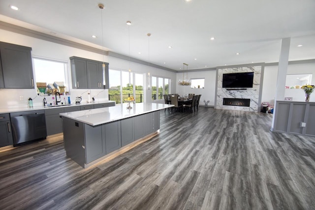 kitchen with dishwasher, gray cabinetry, dark wood-style floors, light countertops, and a kitchen island