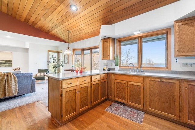 519 Grandview Heights Ct, Menomonie, WI 54751 - kitchen featuring lofted ceiling, a peninsula, brown cabinetry, a sink, and light countertops