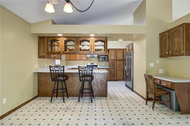1286 Krattley Ln, Hudson, WI 54016 - kitchen featuring appliances with stainless steel finishes, a peninsula, baseboards, range hood, and vaulted ceiling