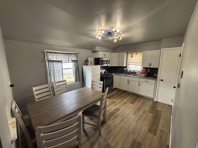 8210 W Winfield Ave, Milwaukee, WI 53218 - dining area with a chandelier, dark wood-style flooring, and vaulted ceiling