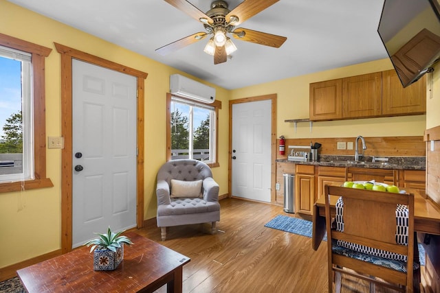 N5101 Hemlock St, Poynette, WI 53955 - living room with a wall mounted AC, a ceiling fan, light wood-style flooring, and baseboards
