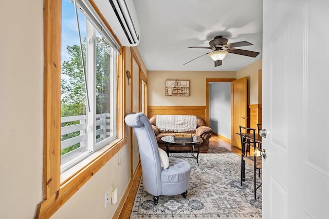 N5101 Hemlock St, Poynette, WI 53955 - living area featuring ceiling fan, a wall mounted AC, a wainscoted wall, wood finished floors, and wood walls