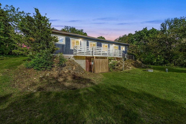 N5101 Hemlock St, Poynette, WI 53955 - back of house at dusk featuring a lawn and a wooden deck