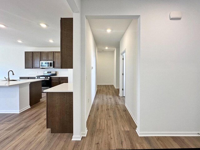 2833 Jackson St, Stoughton, WI 53589 - corridor featuring wood finished floors, a sink, baseboards, and recessed lighting