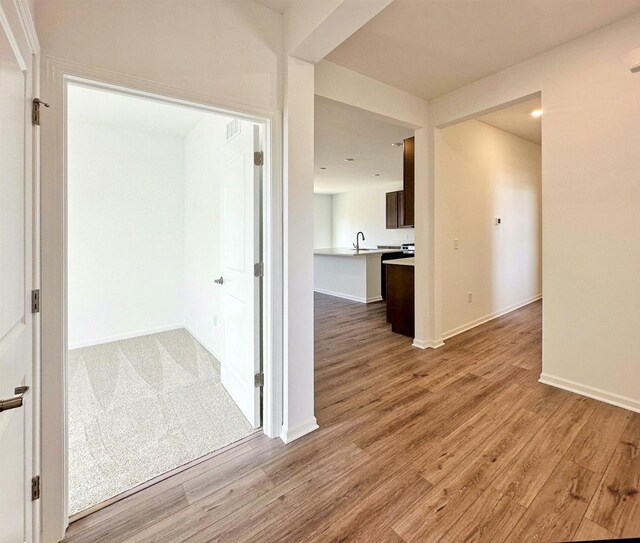 2833 Jackson St, Stoughton, WI 53589 - corridor featuring light wood-type flooring, baseboards, a sink, and recessed lighting