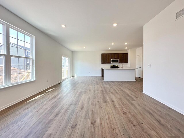 2833 Jackson St, Stoughton, WI 53589 - unfurnished living room with recessed lighting, light wood-type flooring, and baseboards