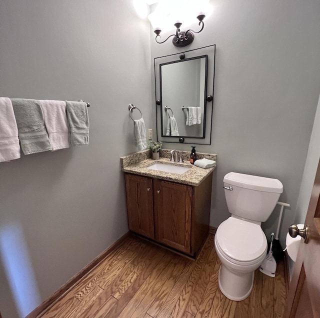 1012 Silent Sunday Ct, Racine, WI 53402 - bathroom featuring wood finished floors, baseboards, toilet, and vanity