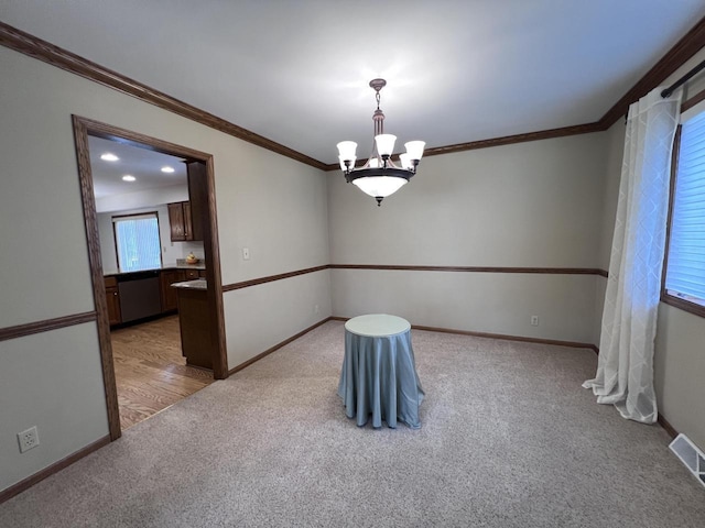 1012 Silent Sunday Ct, Racine, WI 53402 - unfurnished room featuring light colored carpet, crown molding, a chandelier, and baseboards
