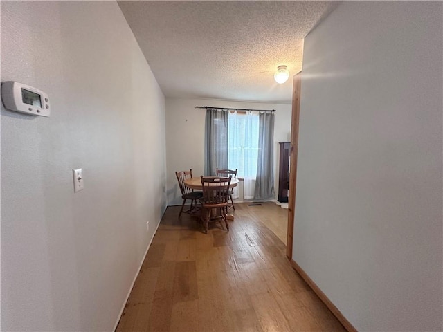 806 W Elm St, Chippewa Falls, WI 54729 - dining space with light wood-style floors, baseboards, and a textured ceiling
