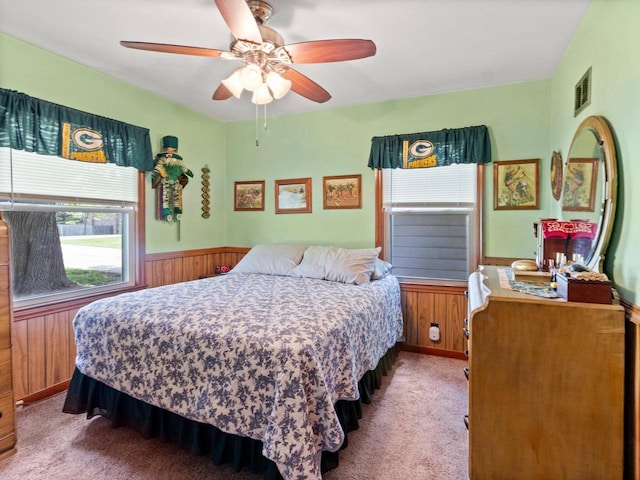 6043 N 118th St, Milwaukee, WI 53225 - carpeted bedroom featuring wood walls, a wainscoted wall, and a ceiling fan
