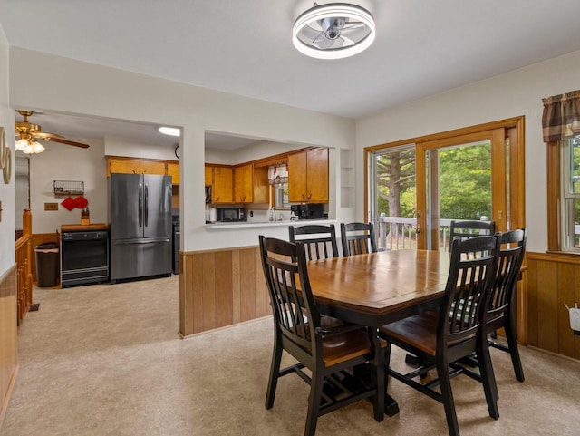 6043 N 118th St, Milwaukee, WI 53225 - dining room featuring wooden walls, a wainscoted wall, light carpet, and ceiling fan