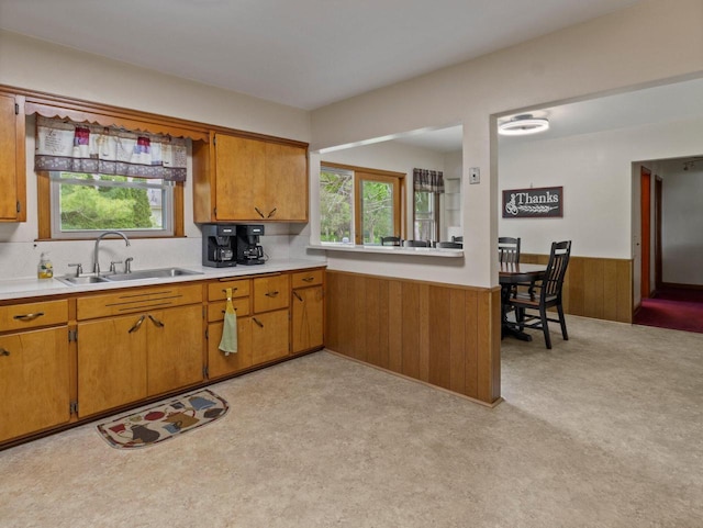 6043 N 118th St, Milwaukee, WI 53225 - kitchen featuring a sink, wainscoting, light countertops, brown cabinets, and wooden walls