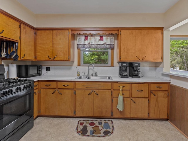 6043 N 118th St, Milwaukee, WI 53225 - kitchen with gas range, a sink, black microwave, light countertops, and brown cabinetry