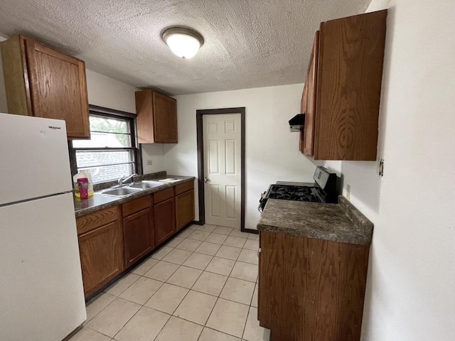 6121 12th Ave, Kenosha, WI 53143 - kitchen with freestanding refrigerator, a sink, stainless steel gas range, dark countertops, and a textured ceiling