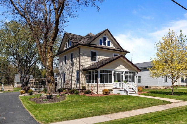 61 N Grand St, Markesan, WI 53946 - american foursquare style home with a sunroom and a front yard
