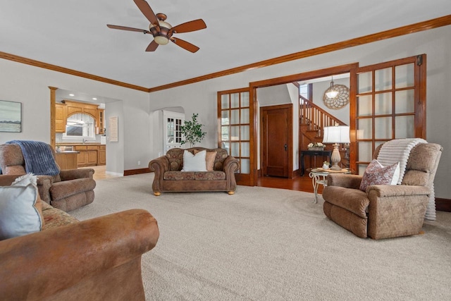 61 N Grand St, Markesan, WI 53946 - living room featuring carpet floors, crown molding, a ceiling fan, baseboards, and stairway