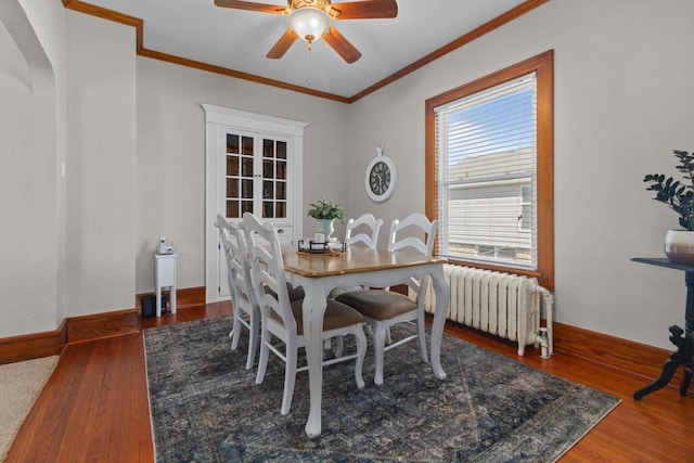 61 N Grand St, Markesan, WI 53946 - dining area with radiator heating unit, a ceiling fan, wood finished floors, crown molding, and baseboards