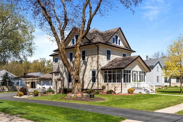 61 N Grand St, Markesan, WI 53946 - view of front of house featuring a sunroom and a front yard