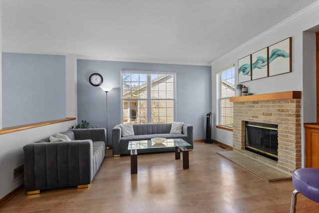 living area featuring ornamental molding, light wood finished floors, a brick fireplace, and baseboards