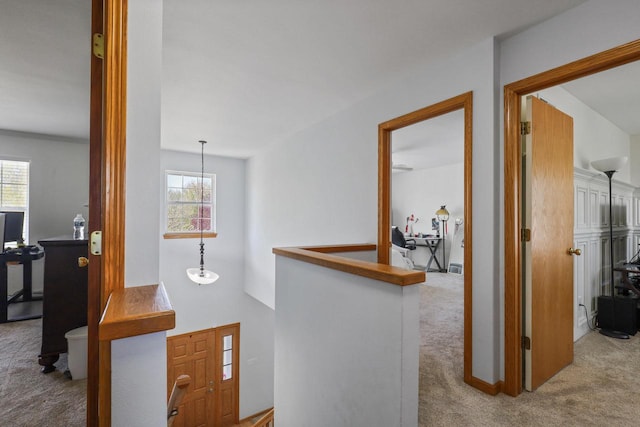 hall featuring carpet floors and an upstairs landing