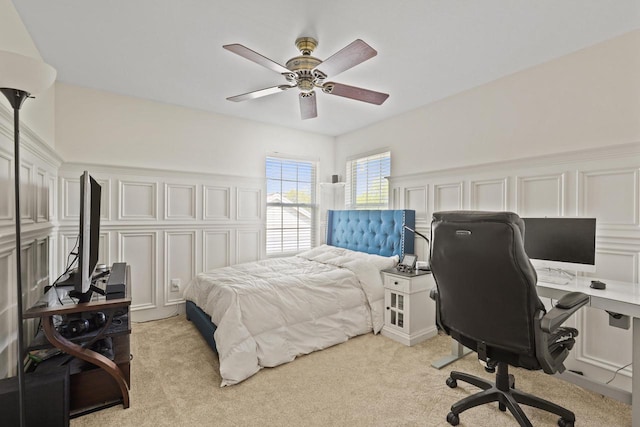 bedroom with a desk, light colored carpet, and ceiling fan