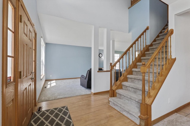 entryway with stairway, baseboards, and wood finished floors