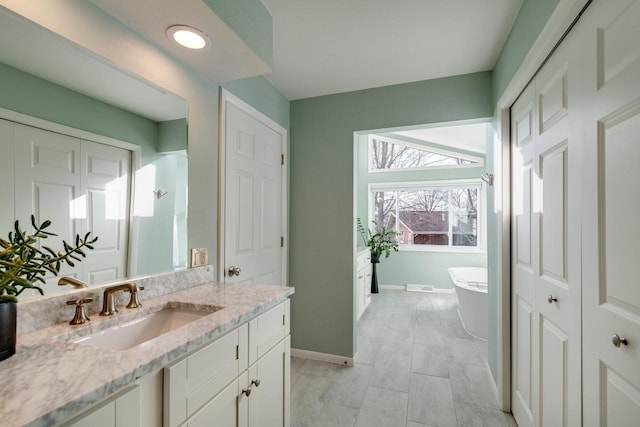5402 Comanche Way, Madison, WI 53704 - bathroom with vanity, a freestanding bath, baseboards, and a closet