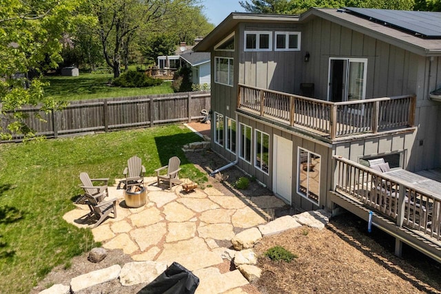 5402 Comanche Way, Madison, WI 53704 - back of house with an outdoor fire pit, a patio area, roof mounted solar panels, a balcony, and board and batten siding