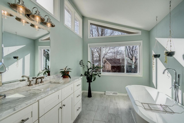 5402 Comanche Way, Madison, WI 53704 - full bathroom with vanity, a freestanding tub, baseboards, and high vaulted ceiling