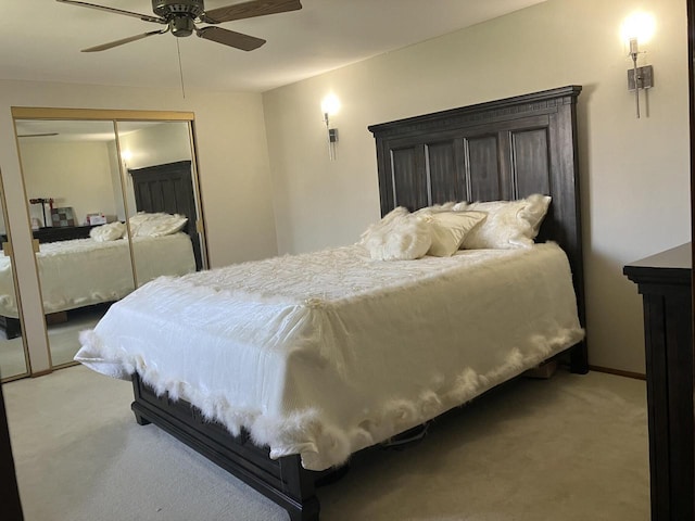 bedroom with light colored carpet, a closet, and a ceiling fan