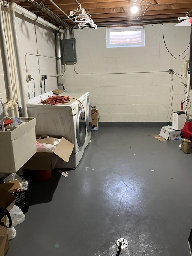below grade area featuring washing machine and clothes dryer, electric panel, and a sink