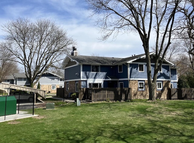 rear view of house featuring a chimney and brick siding
