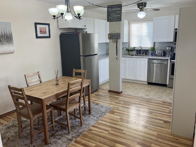 dining room featuring a chandelier, light wood finished floors, and a ceiling fan