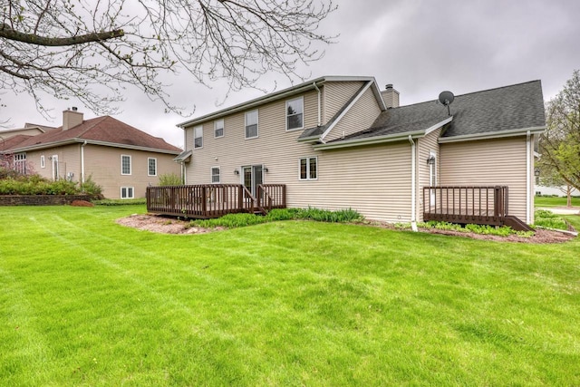 back of property featuring a wooden deck, a yard, and a chimney